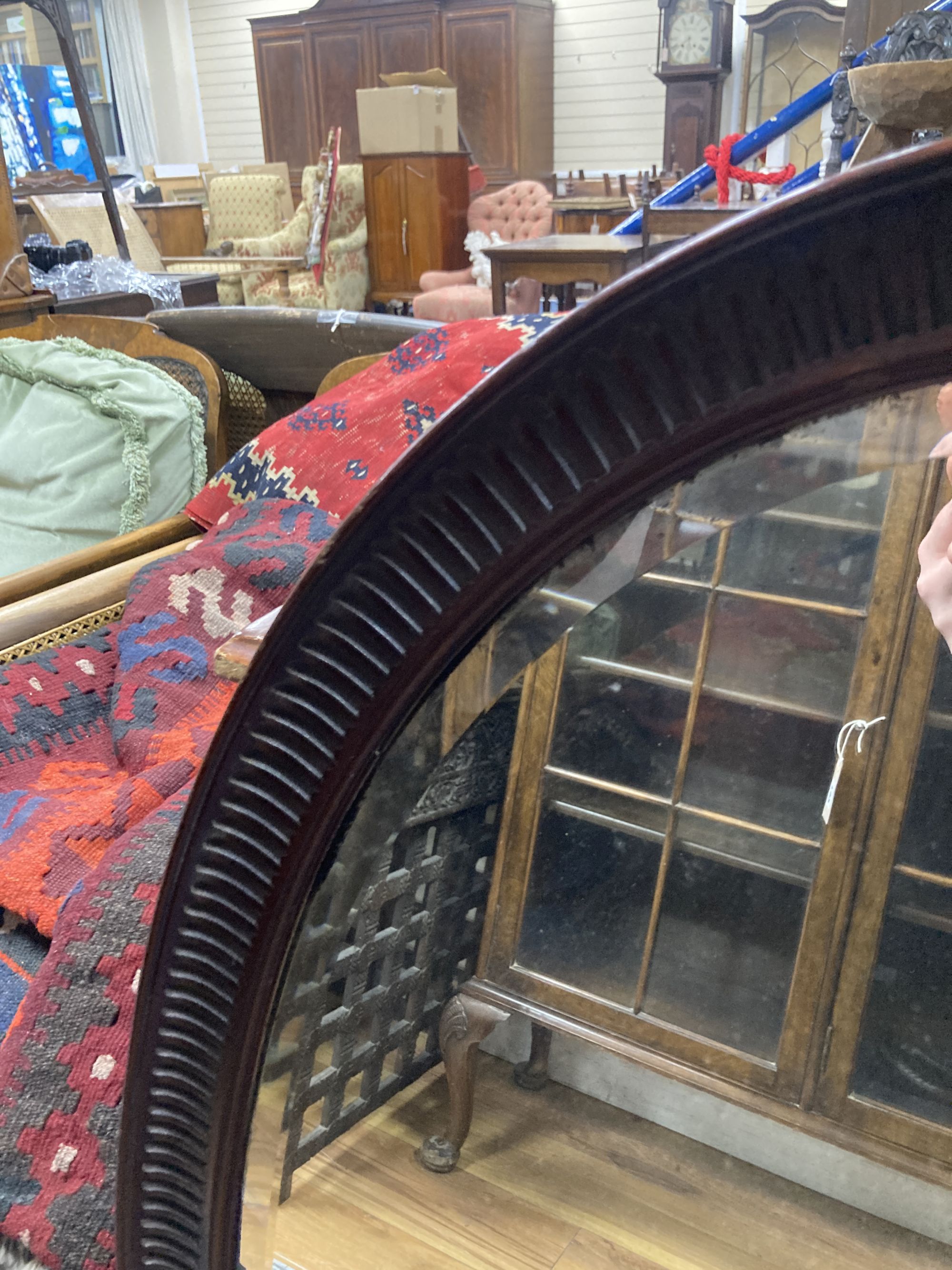 A 1920s oval-framed mahogany wall mirror, width 70cm, height 100cm